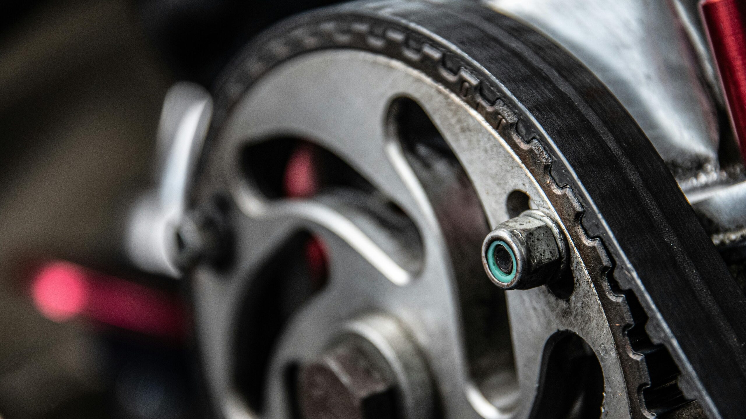 Focused shot of a car engine's metallic timing belt component, essential for maintenance and repair.