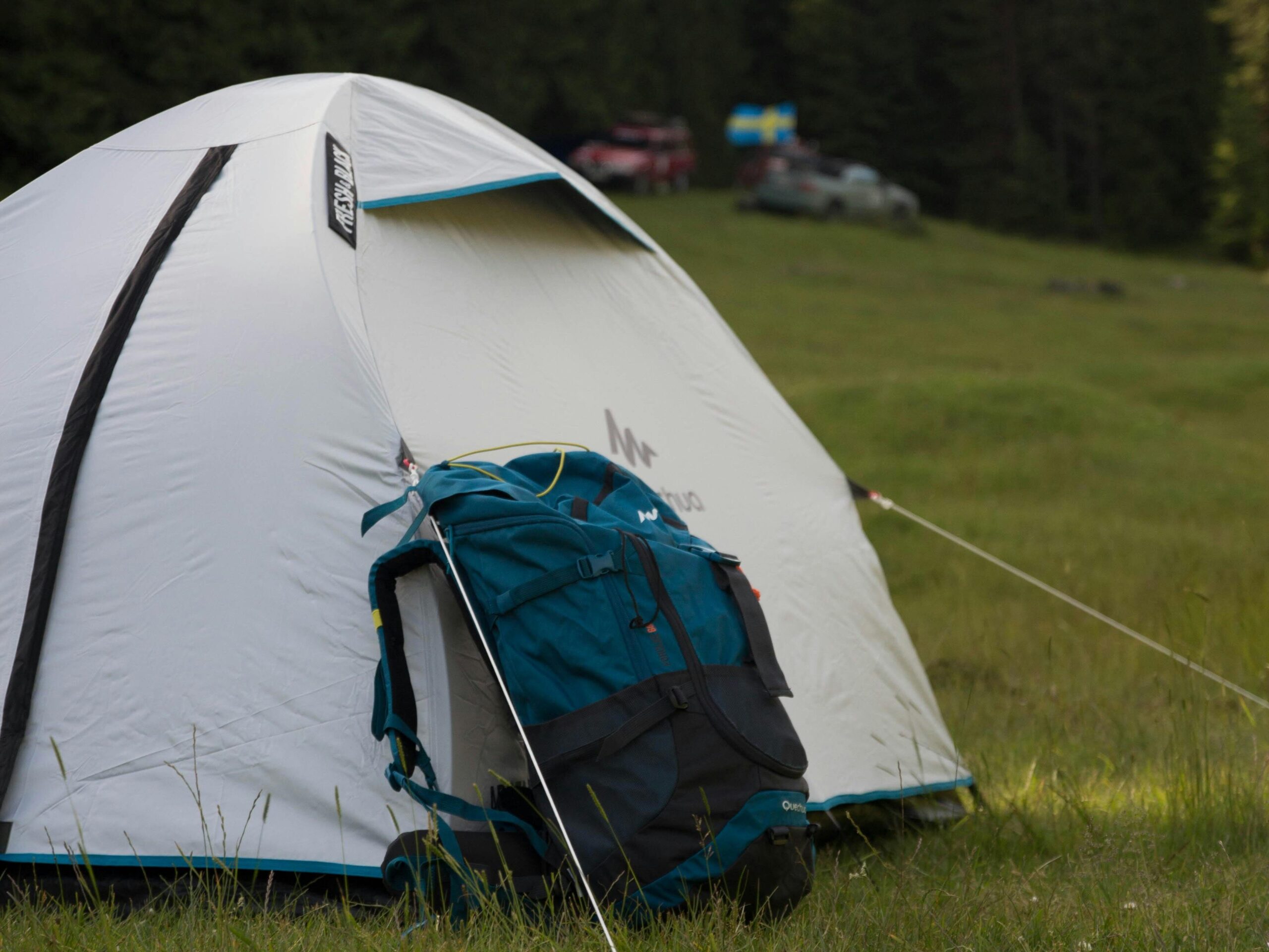 A serene campsite with a tent and backpack in the scenic Padiş forest, Romania.